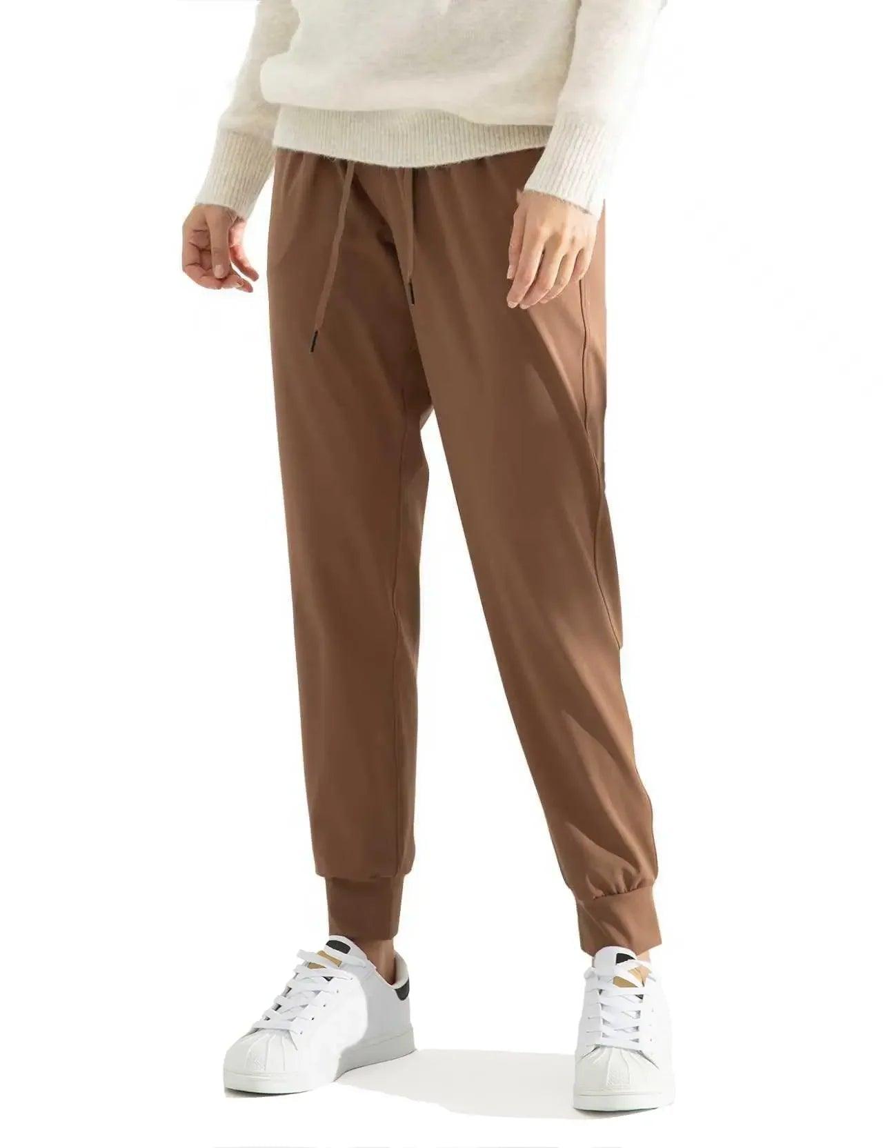 Brown drawstring joggers with white sneakers, styled for women's casual fashion