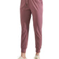 Women's dusty rose joggers with drawstring waist, elastic cuffs, paired with white sneakers for casual fashion.