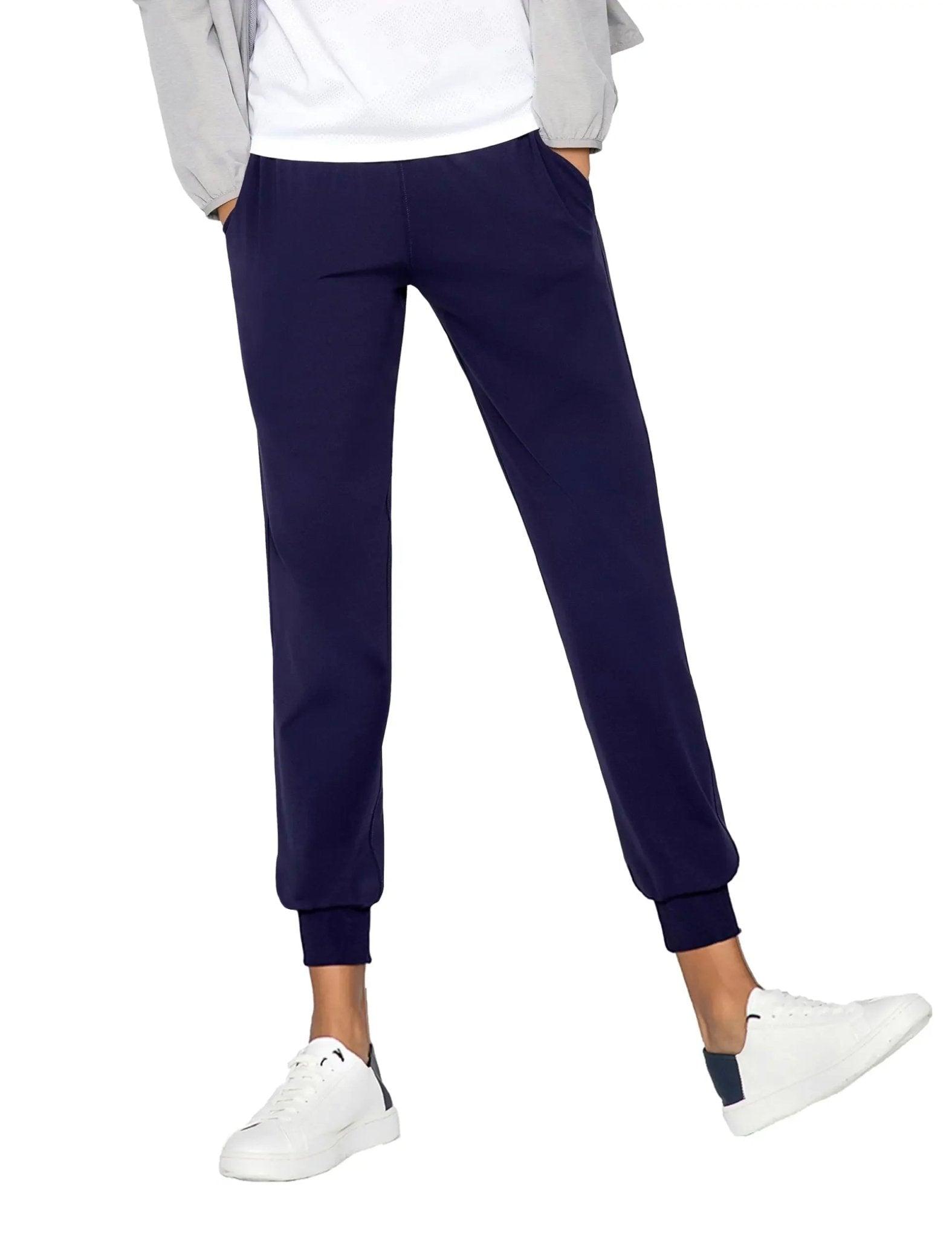 Navy blue women's jogger pants with elastic cuffs, paired with white sneakers and a casual top