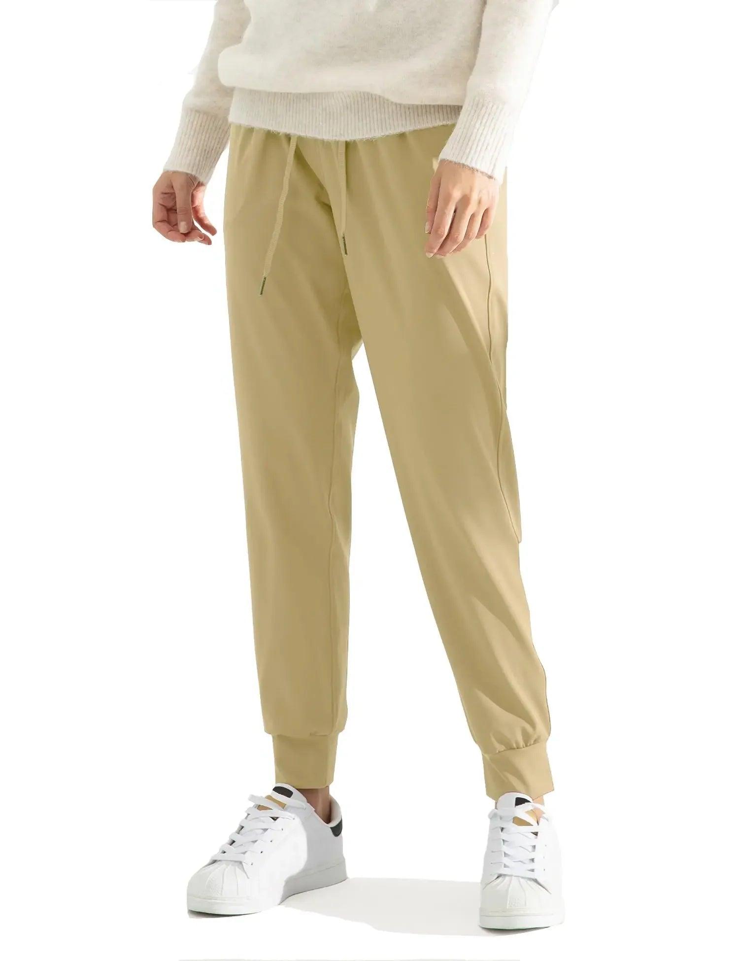 Beige jogger pants with drawstring waist, paired with white sneakers and a cozy sweater for casual women's fashion.