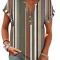 Women's patterned V-neck button-up top with short sleeves, stripes, and geometric prints, paired with jeans.