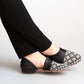 Black and white patterned flats with geometric toe design, worn with black pants for women's fashion