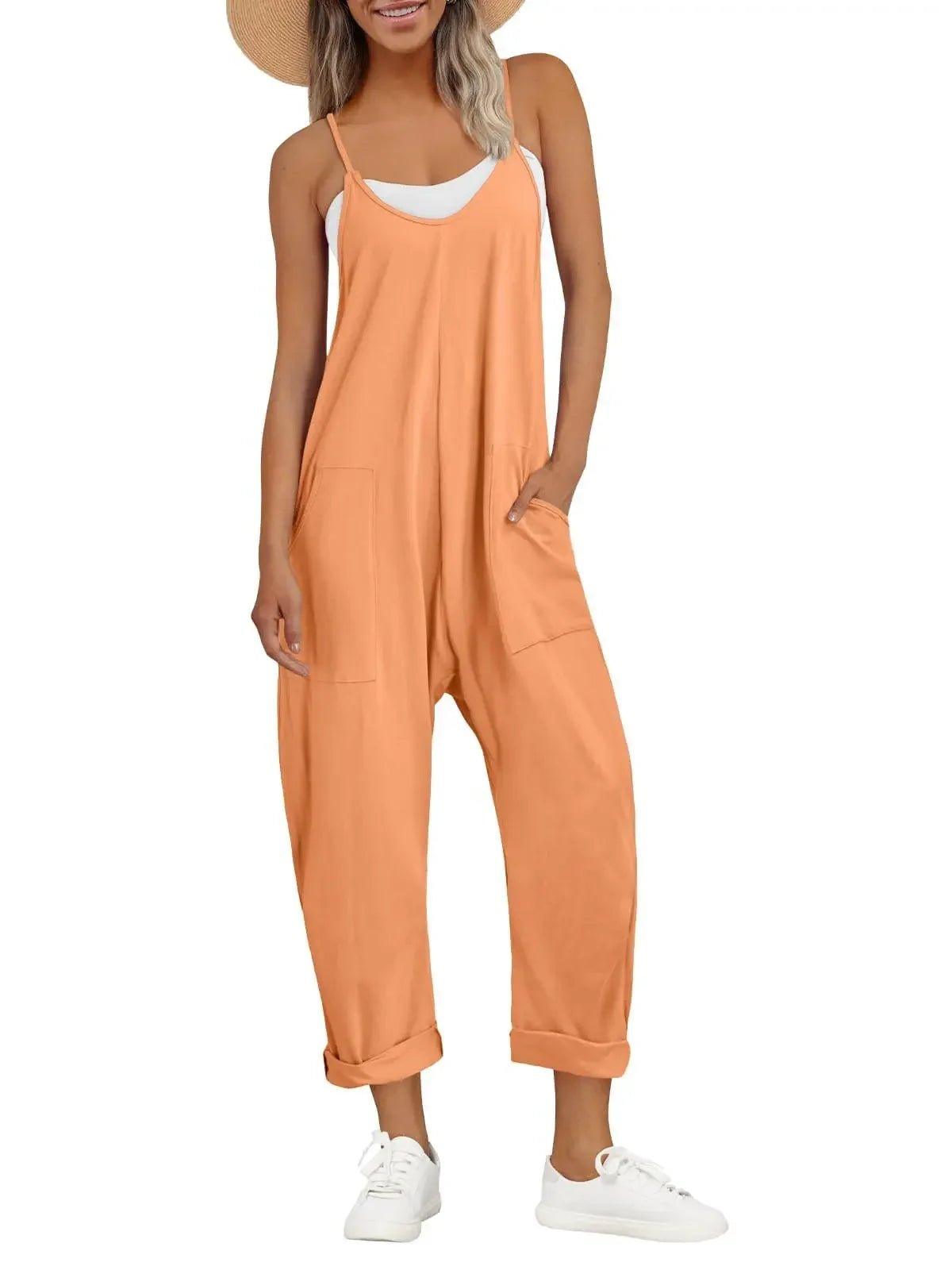 Woman in orange sleeveless jumpsuit with pockets, white sneakers, and straw hat for summer fashion