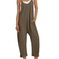 Olive green women's sleeveless jumpsuit with pockets, paired with white sneakers and straw hat