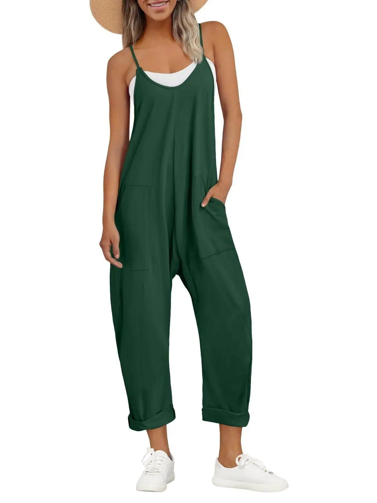 Woman in green sleeveless jumpsuit with pockets, white sneakers, and straw hat for casual fashion
