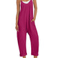 Woman in magenta sleeveless jumpsuit with pockets, straw hat, white sneakers — casual fashion outfit