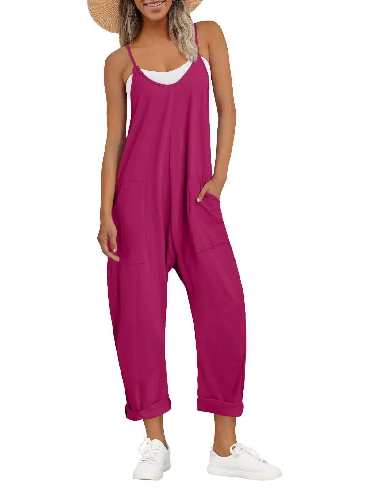 Woman in magenta sleeveless jumpsuit with pockets, straw hat, white sneakers — casual fashion outfit