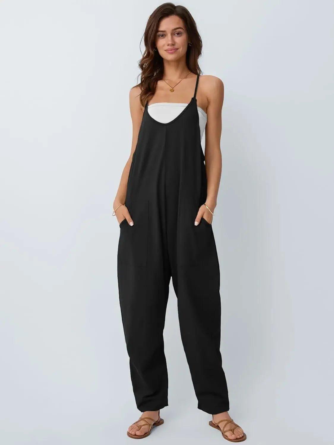 Woman wearing black sleeveless jumpsuit with pockets, paired with white top and sandals, stylish fashion outfit