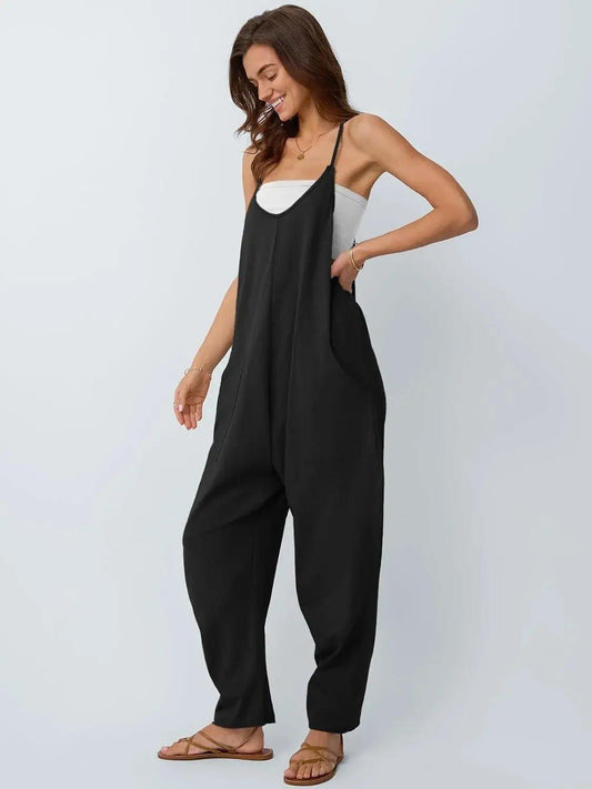 Woman in black sleeveless jumpsuit with wide legs, paired with white top and sandals, fashion outfit