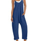 Woman in blue sleeveless jumpsuit with pockets, white sneakers, and straw hat for summer fashion