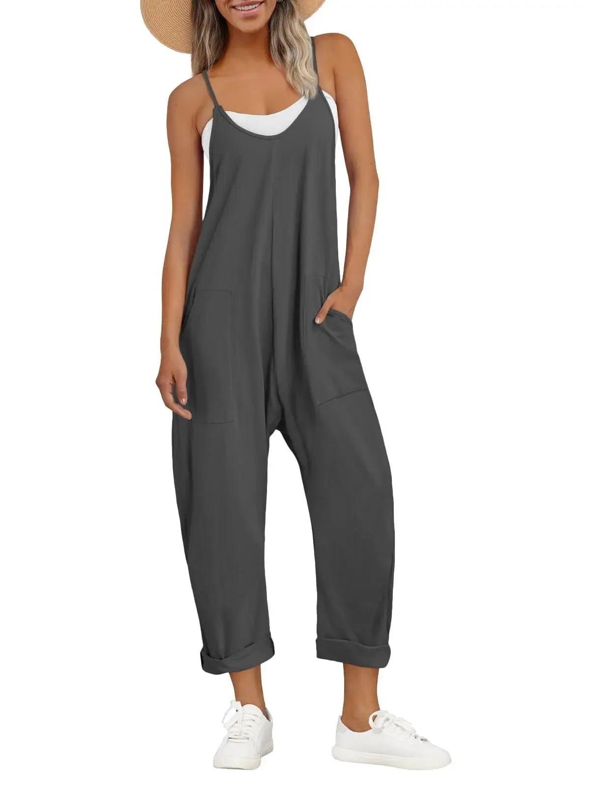 Woman in gray sleeveless jumpsuit with pockets, white sneakers, and straw hat for casual fashion