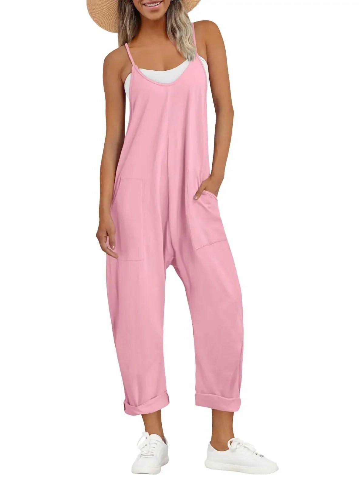 Pink women's jumpsuit with pockets, white sneakers, and straw hat for casual summer fashion