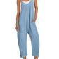 Light blue women's jumpsuit with pockets, white sneakers, and straw hat for casual summer fashion