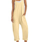 Yellow women's jumpsuit with pockets, straw hat, and white sneakers for casual summer fashion