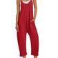 Red women's jumpsuit with pockets, white sneakers, and straw hat for summer fashion