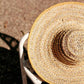Wide-brimmed straw sun hat with yellow trim, perfect for summer fashion and beach outings