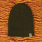Olive green ribbed knit beanie with owl tag on patterned background, women's fashion accessory