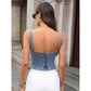 Woman wearing backless denim corset top with zipper, white pants, sunglasses, and gold jewelry