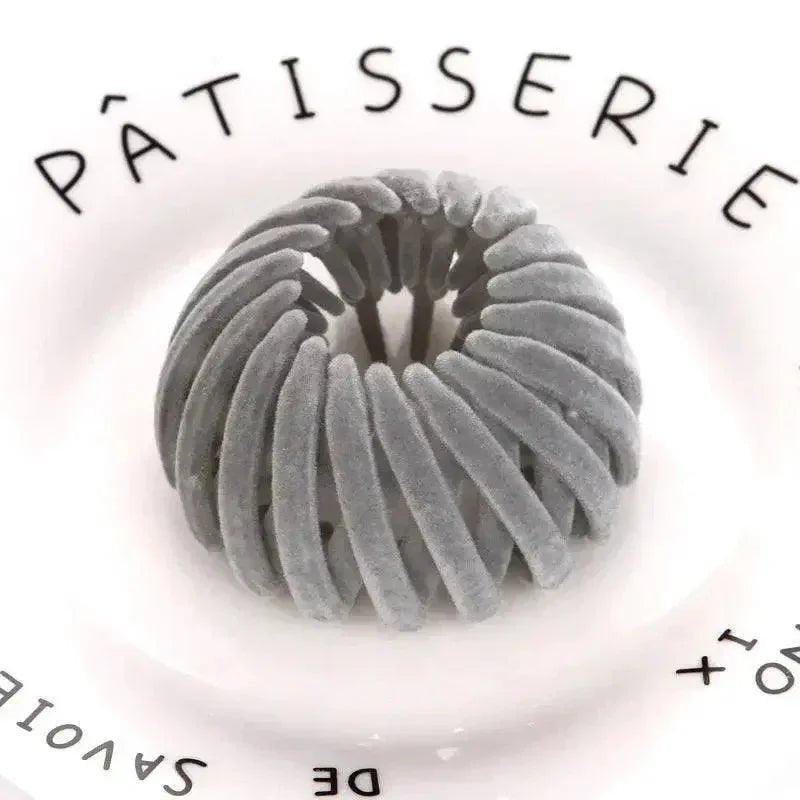 Gray velvet hair scrunchie on white plate with Pâtisserie text, women's fashion accessory