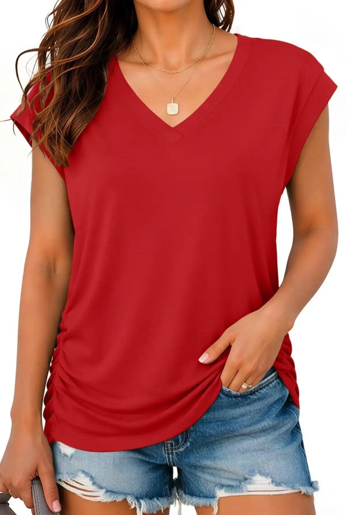 Red V-neck women's fashion top with ruched side, paired with distressed denim shorts