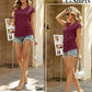 Woman in burgundy cap sleeve V-neck t-shirt with denim shorts, stylish summer outfit