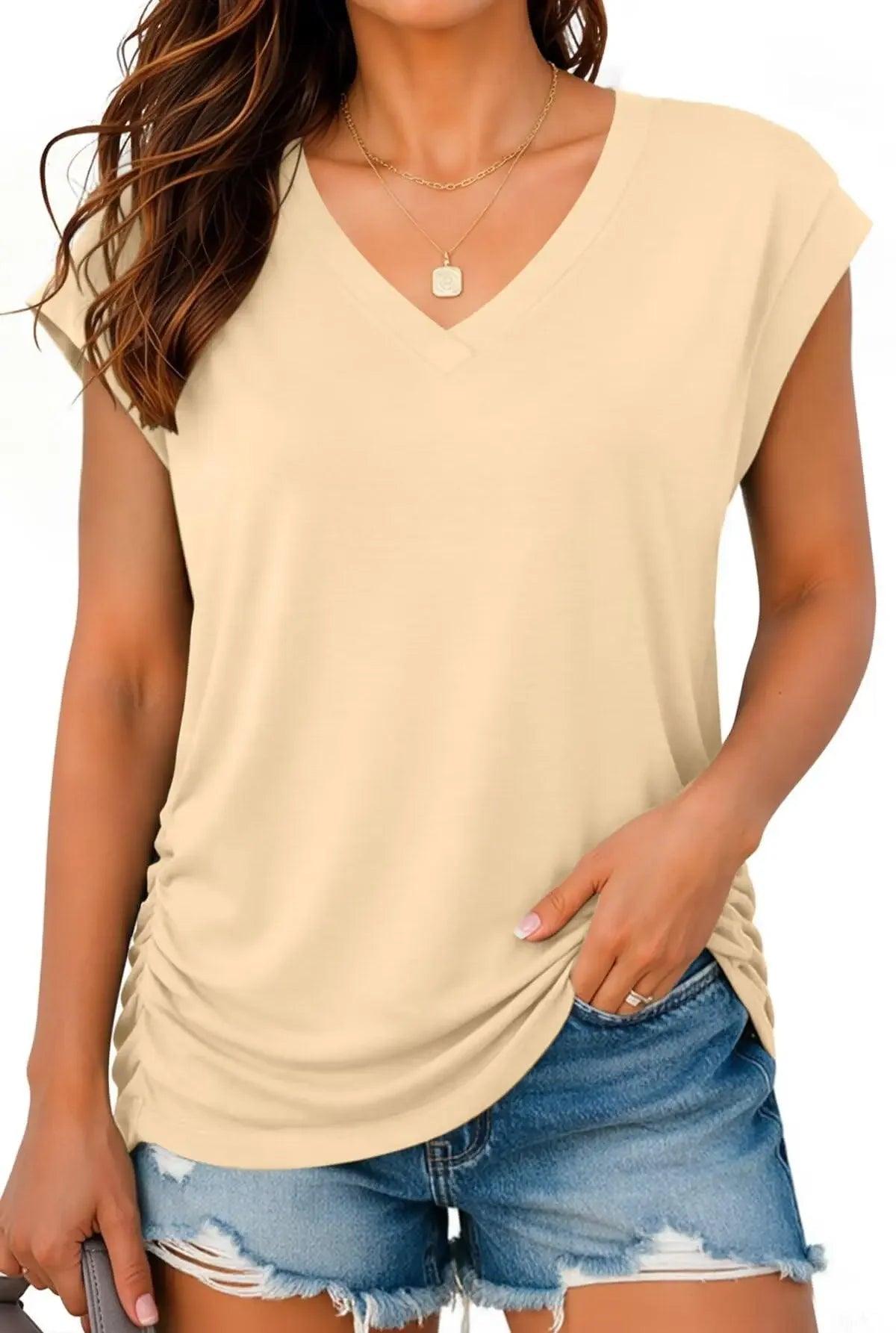 Beige V-neck women's fashion top with ruched side, paired with denim shorts for casual style