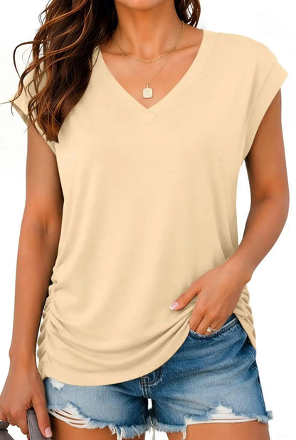Beige V-neck women's fashion top with ruched side, paired with denim shorts for casual style