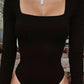 Black long sleeve bodysuit with square neckline and high-cut legs, styled with layered chain necklace