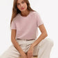 Woman in soft pink t-shirt and beige pants, stylish casual fashion outfit