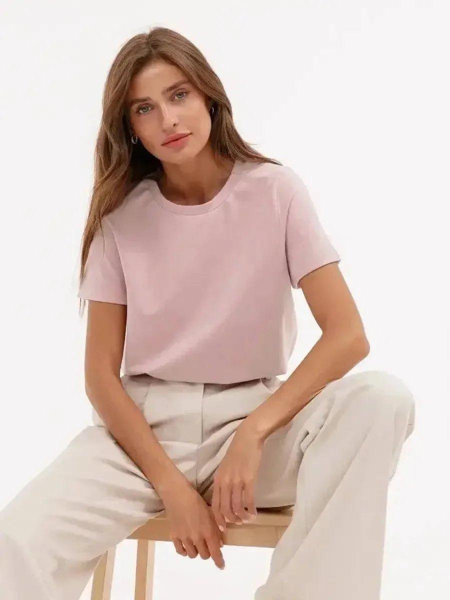 Woman in soft pink t-shirt and beige pants, stylish casual fashion outfit
