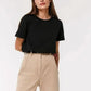 Woman in black crop top and beige high-waist pants, stylish casual fashion outfit