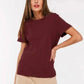 Woman wearing burgundy t-shirt and beige pants, stylish casual fashion