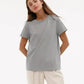 Woman modeling a light gray oversized t-shirt with white pants, casual fashion outfit