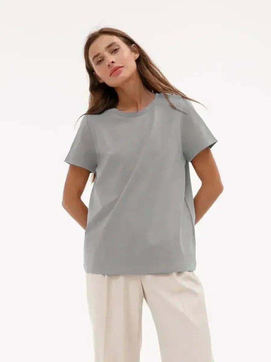 Woman modeling a light gray oversized t-shirt with white pants, casual fashion outfit