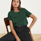 Woman modeling green t-shirt and black pants, stylish casual fashion outfit