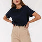 Woman modeling navy blue crop top with beige high-waist pants, stylish casual fashion outfit