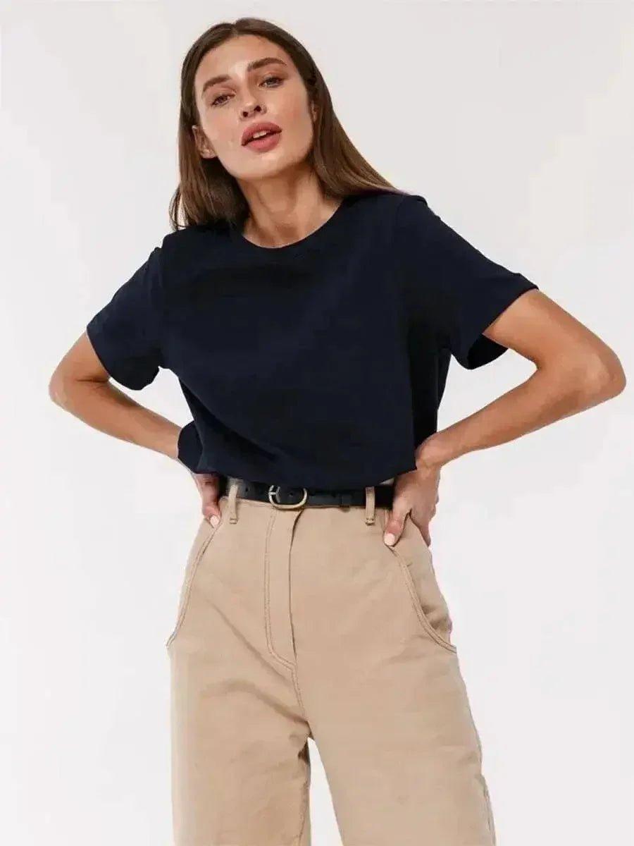 Woman modeling navy blue crop top with beige high-waist pants, stylish casual fashion outfit
