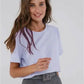 Woman in light blue t-shirt and gray pleated pants, casual fashion outfit