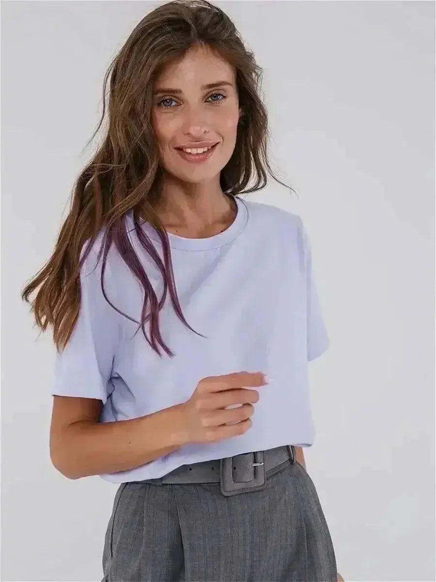 Woman in light blue t-shirt and gray pleated pants, casual fashion outfit
