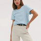 Woman in light blue t-shirt and white pants, casual fashion outfit