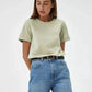 Woman wearing mint green t-shirt and high-waisted blue jeans, casual fashion outfit