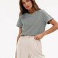 Woman wearing casual gray t-shirt and white wide-leg pants, stylish everyday outfit