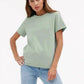 Woman wearing mint green oversized t-shirt with blue jeans, casual fashion outfit