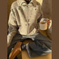 Cozy women's patterned zip-up sweater with jeans and boots, holding coffee mug