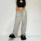 Woman in black crop top and gray wide-leg sweatpants with fuzzy black platform sandals