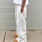 Gray striped sweatpants with side stripes, paired with cozy slippers, ideal for casual fashion.