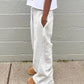 Gray striped sweatpants with side stripes, paired with cozy slippers, ideal for casual fashion.