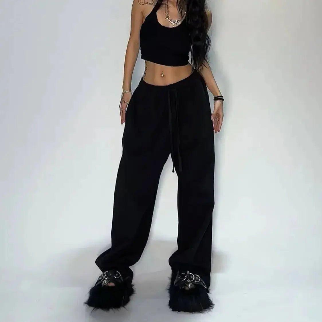 Woman in black crop top, wide-leg pants, and fuzzy platform sandals for trendy fashion look