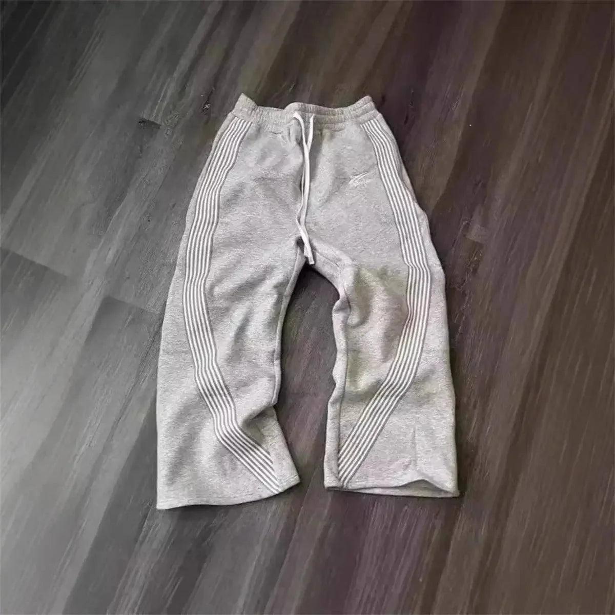 Gray women's sweatpants with side stripes, casual fashion joggers on wood floor