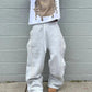 Gray striped sweatpants with drawstring waist, paired with graphic tee and brown boots, casual streetwear style